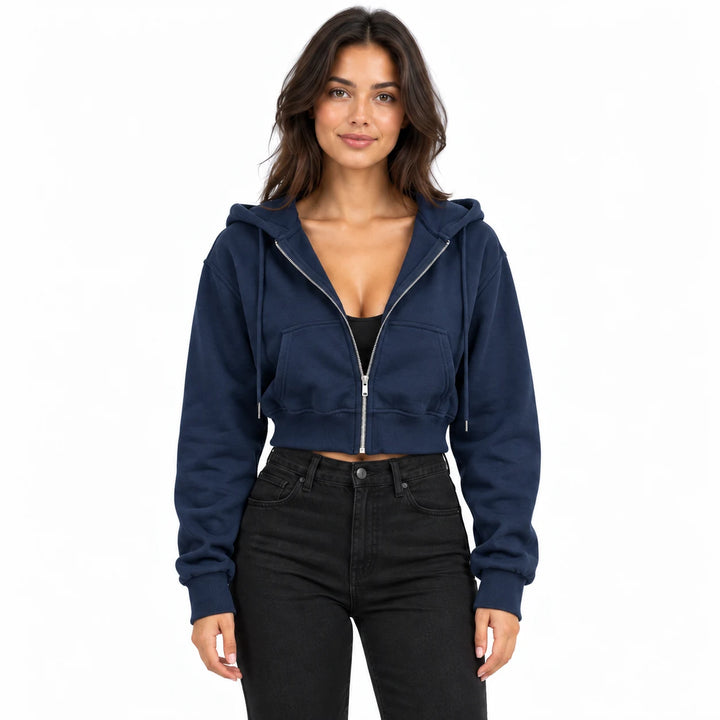 Navy blue hoodie on a model in an upper-body studio view, showing split front pockets, long sleeves and a cropped ribbed hem.