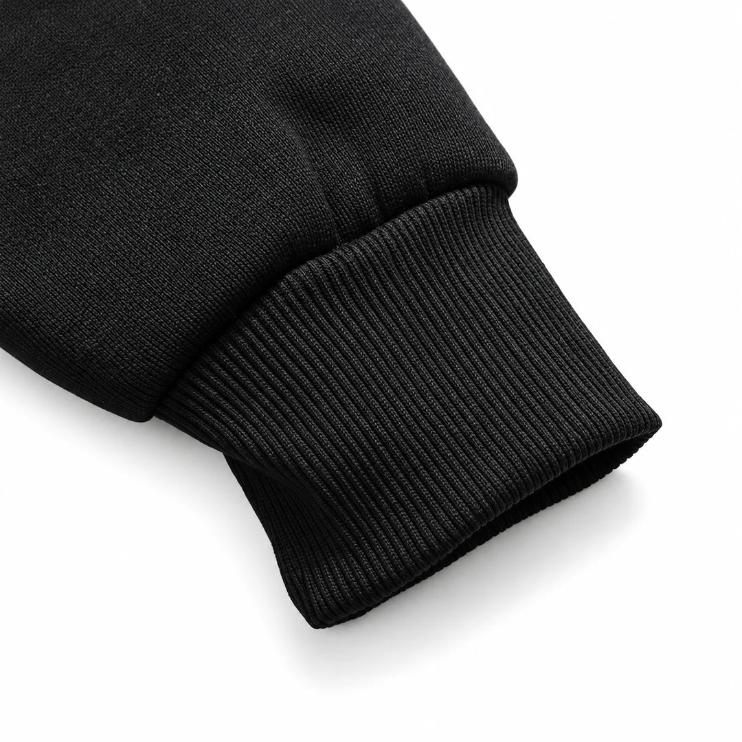 Close-up of a black ribbed hoodie cuff and sleeve seam.