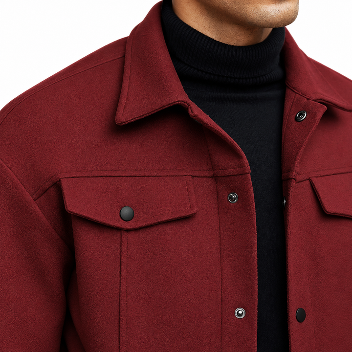 Close-up of the wine red jacket collar and flap chest pocket, showing black snaps and visible exterior texture against white.