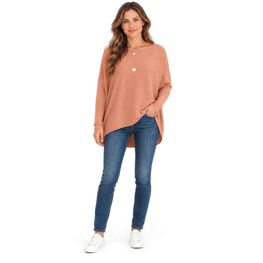 Adult woman wearing the Amber batwing sweater with a high-low hem, in a full-body studio view against a plain white backdrop.