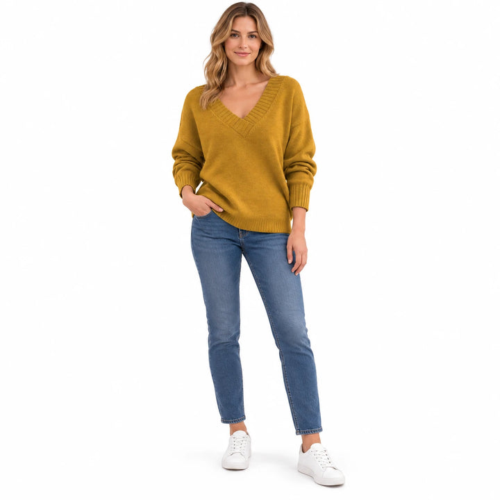 Adult woman modelling the Turmeric V-neck knit pullover, in a full-length front view against a plain white studio background.