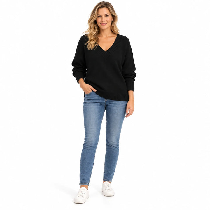 Adult woman shown wearing the Black V-neck knit pullover, in a full-body studio view against a plain white studio background.