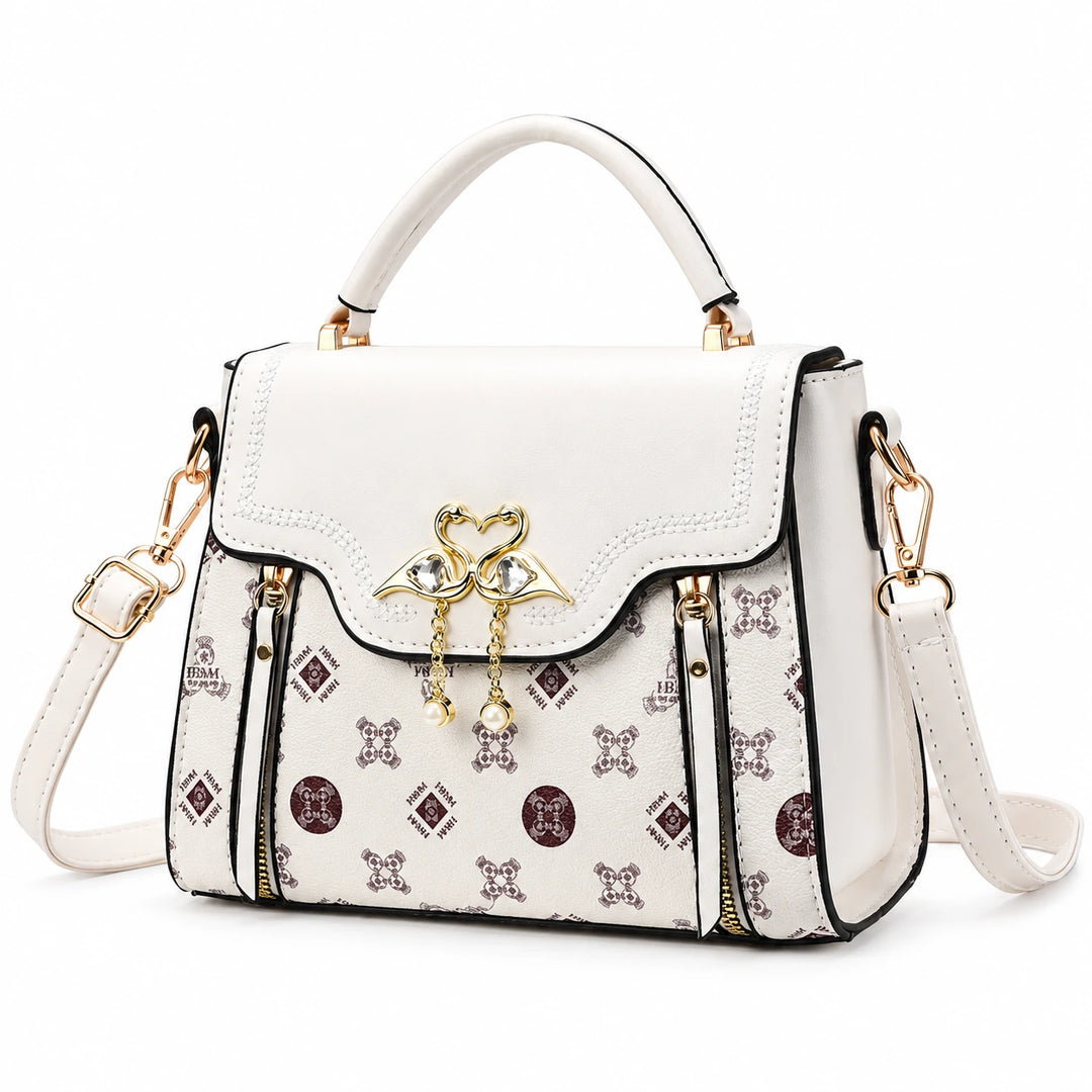 Ivory square crossbody bag with patterned front and flap closure on a white background.