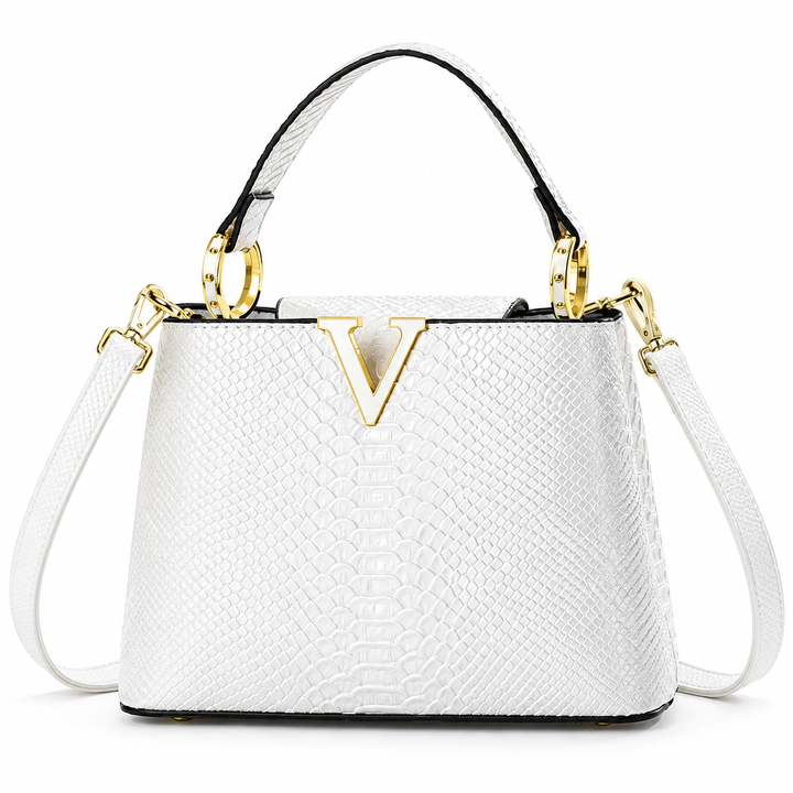 White crossbody bag in front product view showing the embossed scale pattern, top handle, shoulder strap and gold V ornament.