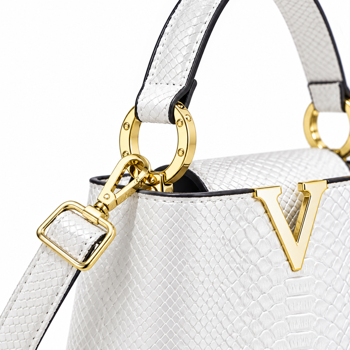 Close-up of the white handbag handle attachment and gold-tone ring, highlighting the photographed strap hardware in a studio.