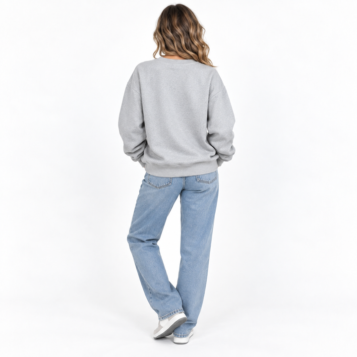 Back view of relaxed unisex sweatshirt showing the garment shape, long sleeves and ribbed hem in a clean studio setting view.