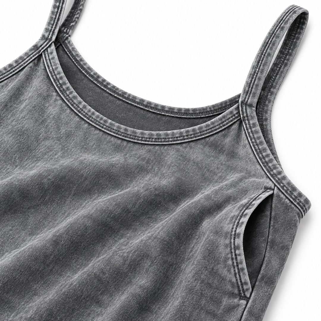 Close-up of gray washed dress fabric, neckline stitching, thin straps and side pocket construction