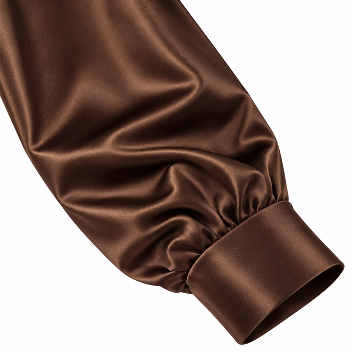 Close view of the brown shirt sleeve and cuff, showing visible folds and satin-look surface isolated on the white background.