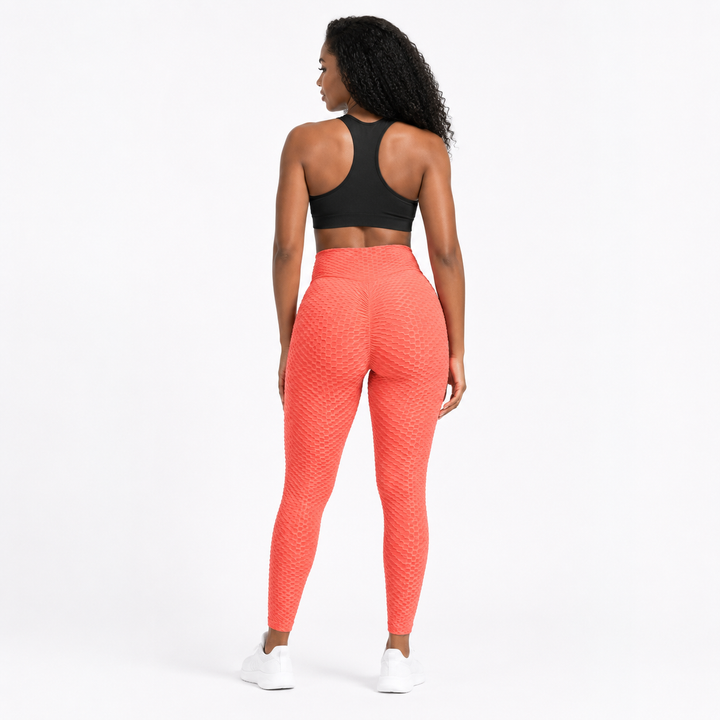 Coral scrunch leggings shown from the back on an adult model, highlighting the high waist, textured finish and center seam.
