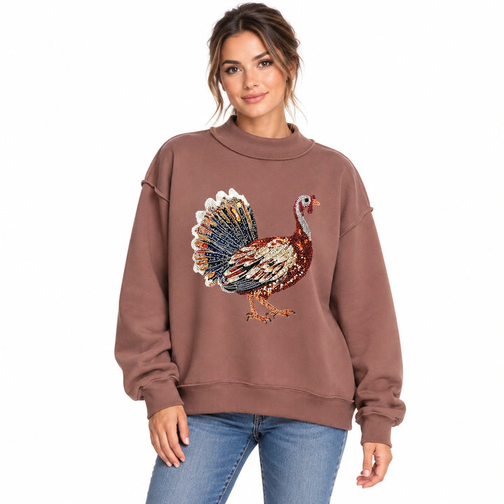 Woman wearing the dark brown sequin Thanksgiving sweatshirt with blue jeans