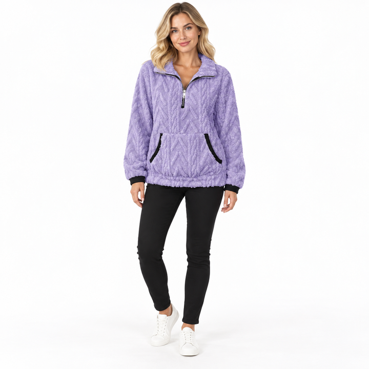 Purple textured zip-neck pullover on a blonde model in black trousers and white sneakers, showing black cuffs and zip collar.