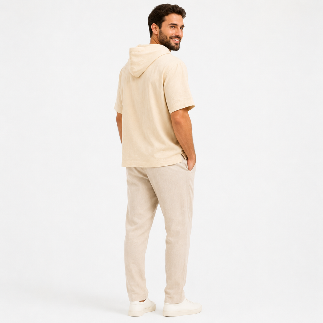 Man wearing an apricot short sleeve hoodie, rear view showing the hood and relaxed back drape.