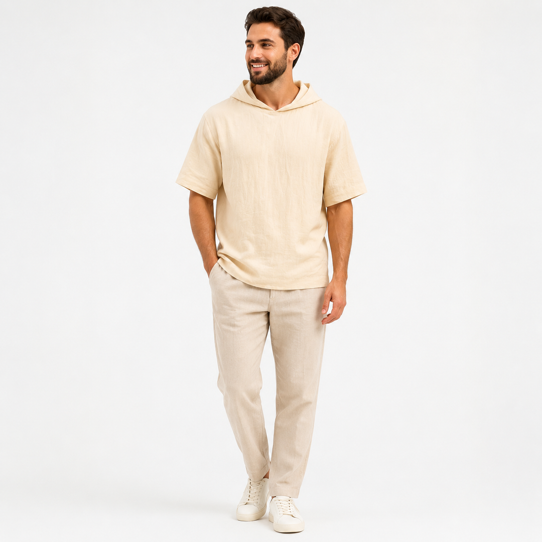 Man wearing an apricot short sleeve pullover hoodie, full-body front view on a white studio background.