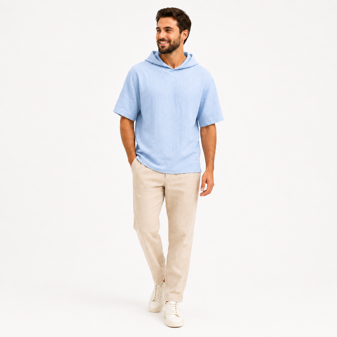 Man wearing a sky blue short sleeve pullover hoodie, walking pose on a clean white studio background.