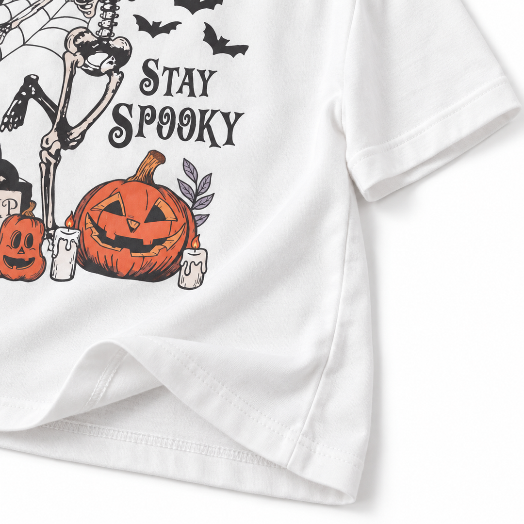 Close-up of T-shirt hem sleeve stitching and Stay Spooky pumpkin print detail