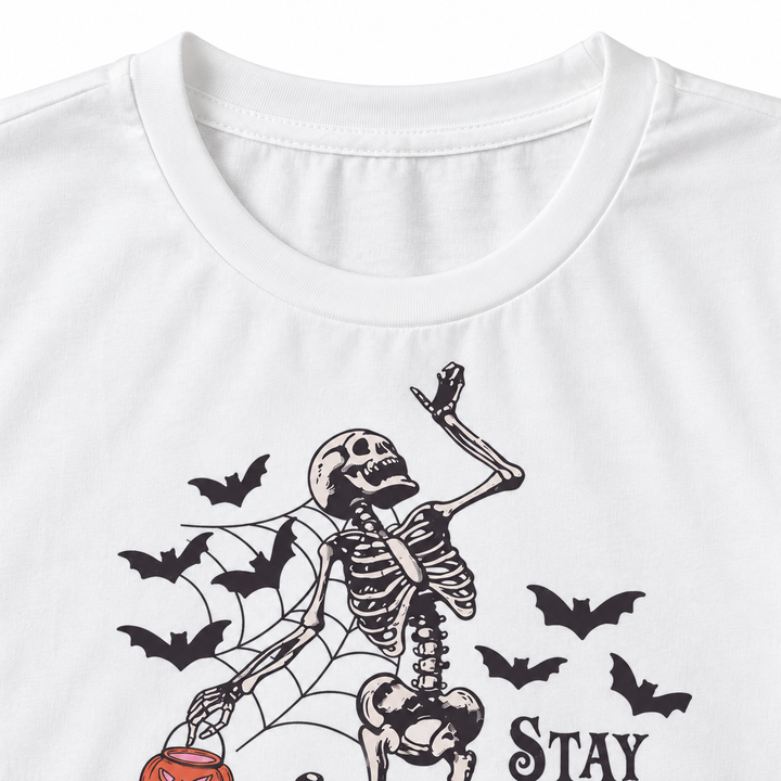 Close-up of white T-shirt neckline with skeleton bats and spiderweb print detail