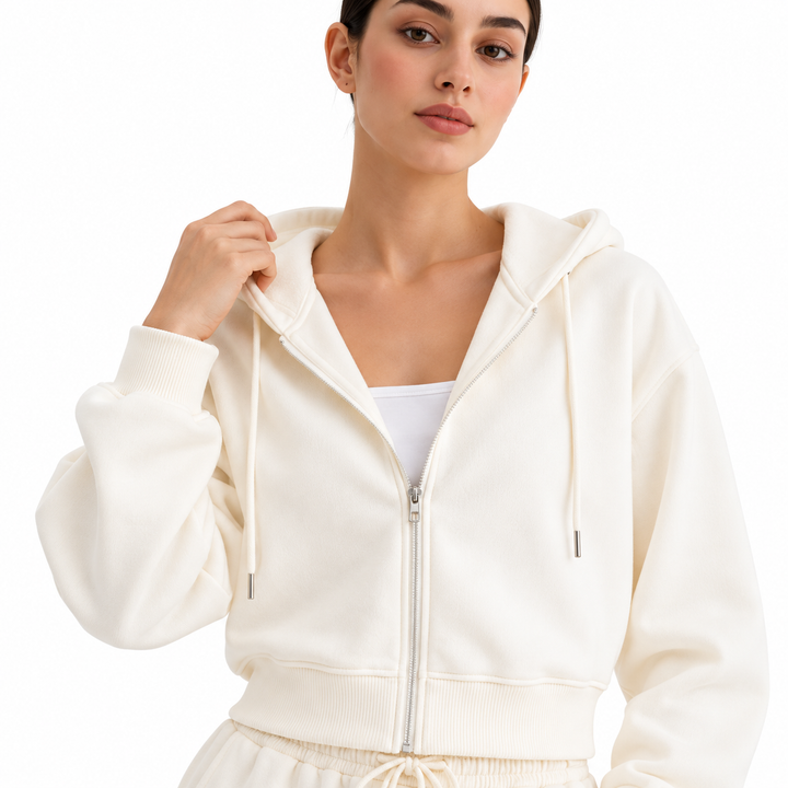 Close-up of white tracksuit zip hoodie showing hood, zipper, drawstrings and ribbed cuff