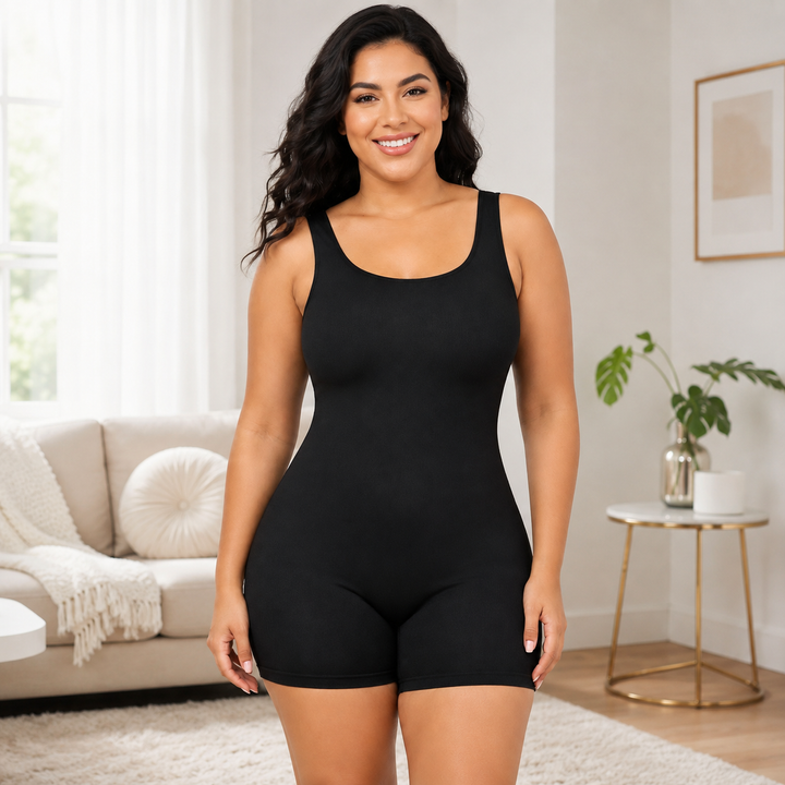 Black shapewear bodysuit lifestyle view on a model in bright interior keeping the sleeveless one-piece design in clear focus.