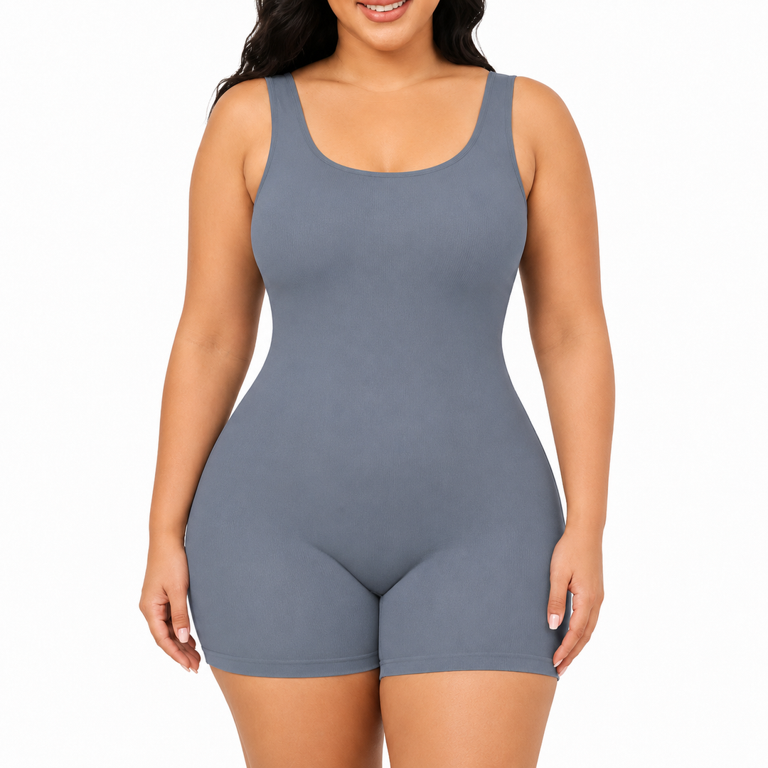 Blue shapewear bodysuit front view on a model showing wide straps, scoop neckline, smooth body and mid-thigh shorts on white.