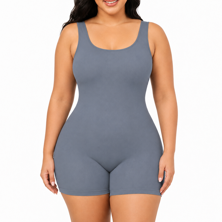 Blue shapewear bodysuit front view on a model showing wide straps, scoop neckline, smooth body and mid-thigh shorts on white.