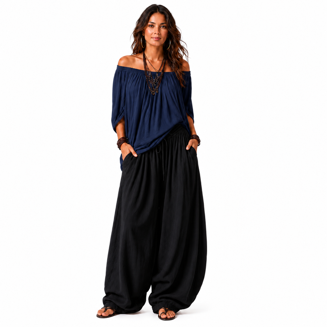 Woman wearing a navy blue off-shoulder top and black gathered pants, front catalog view on a white background.