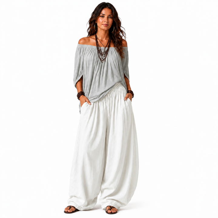Woman wearing a gray off-shoulder top and white gathered pants, full-body view on a clean white background.