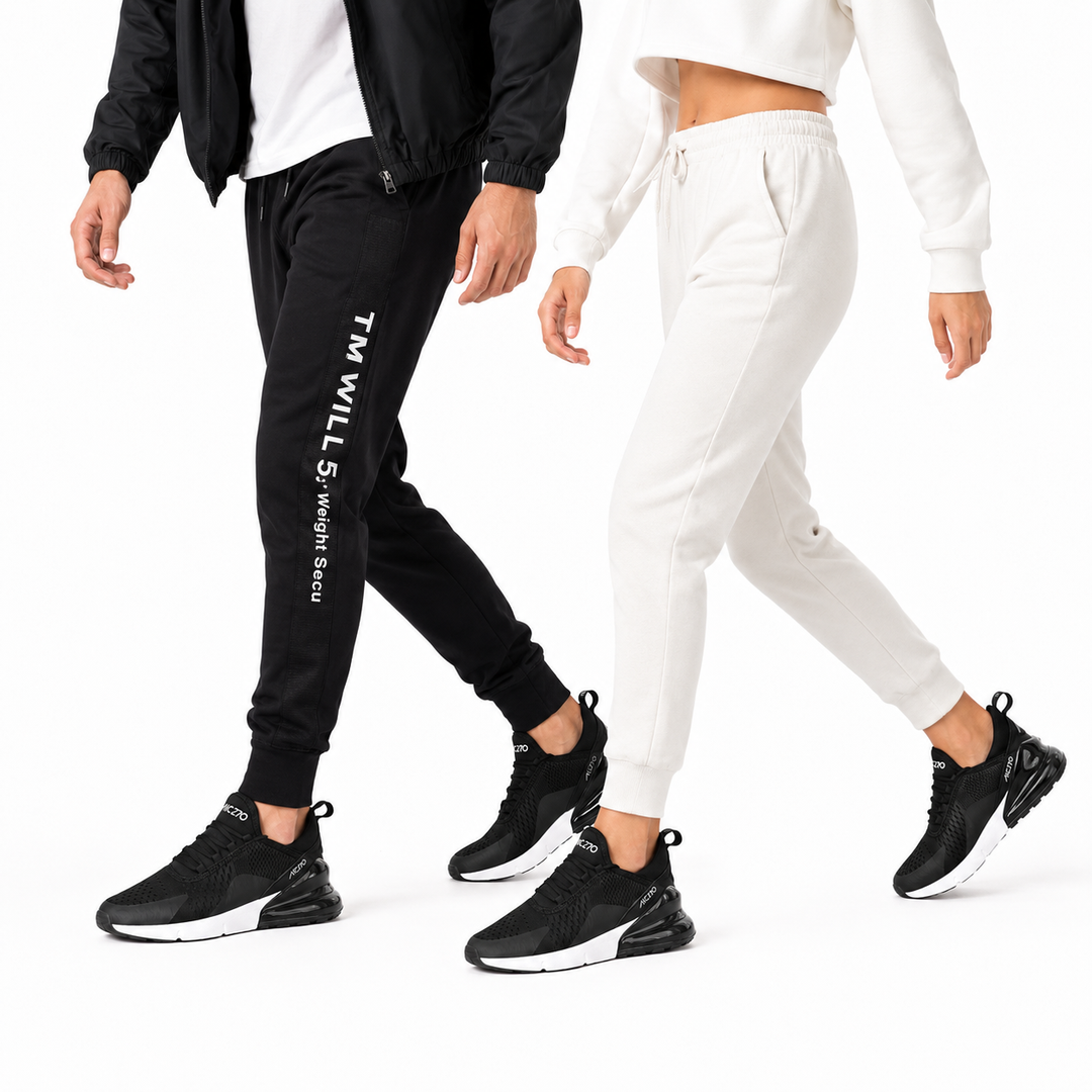 Man and woman wearing black Unisex Max Air running shoes in a studio walking pose on white.