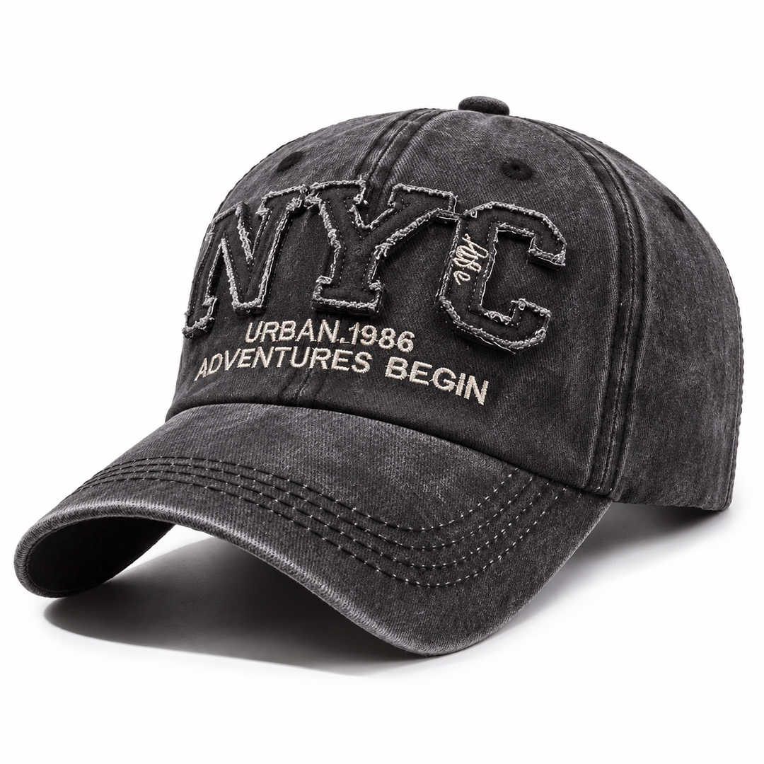 Charcoal black adjustable NYC baseball cap shown alone on white with curved brim, washed finish and raised embroidered front.