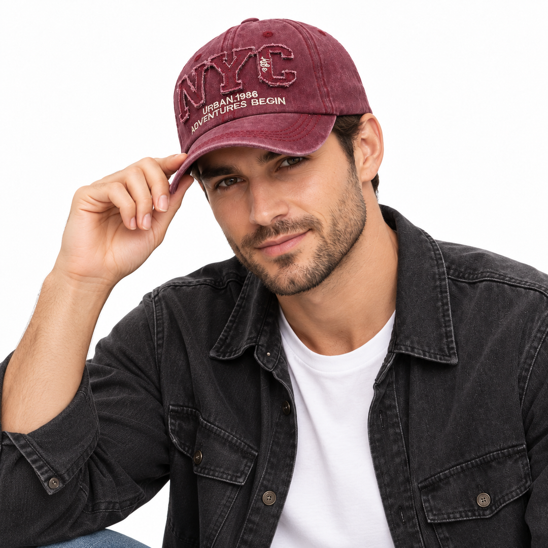 Man wearing the burgundy adjustable NYC baseball cap with curved brim and embroidered front on a clean white studio background.