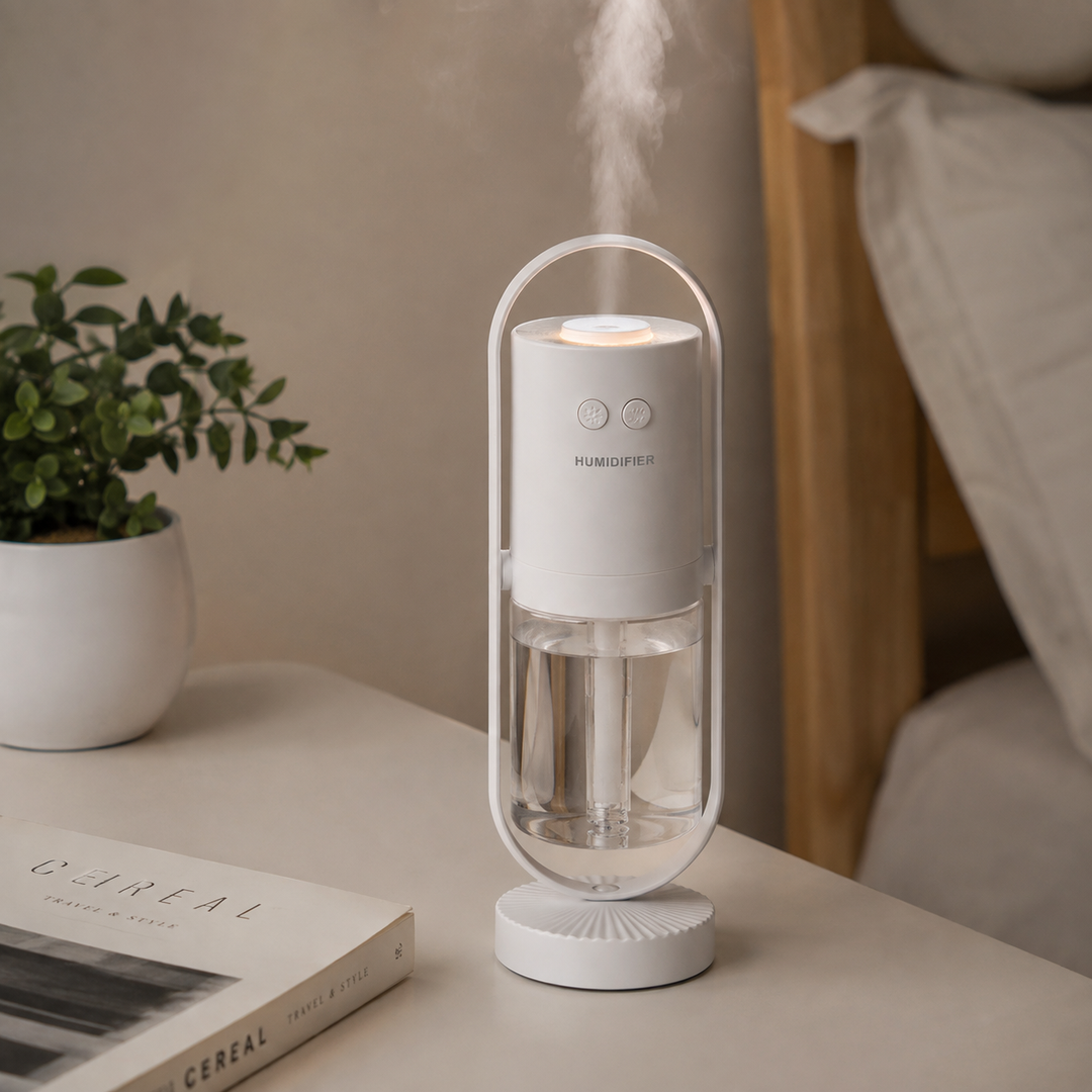 USB humidifier in white producing mist on a bedside with clear 200ML reservoir, color lamp and minimal home interior setting.