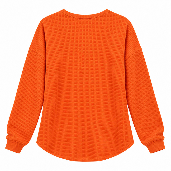 Orange waffle long sleeve pullover shown flat from the back with relaxed shape and textured surface