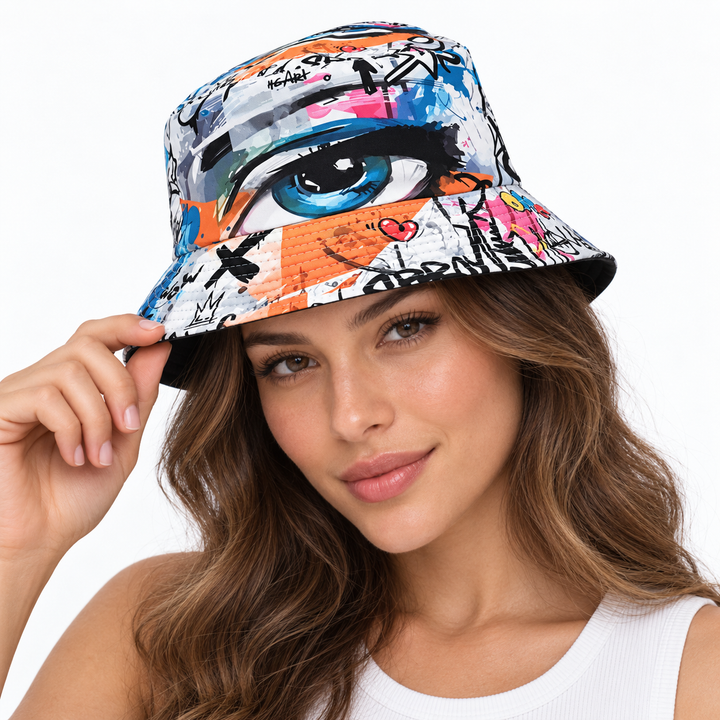 Adult female model wearing the graffiti eye print bucket hat on a clean white studio background, highlighting the printed crown and brim.