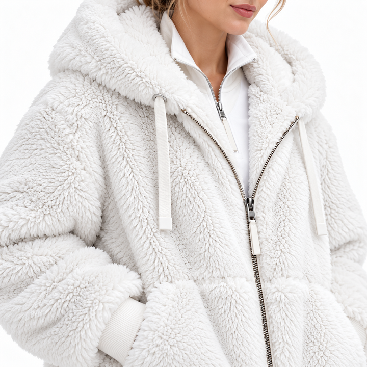 White hooded jacket close-up showing textured fleece surface, zipper and drawstrings
