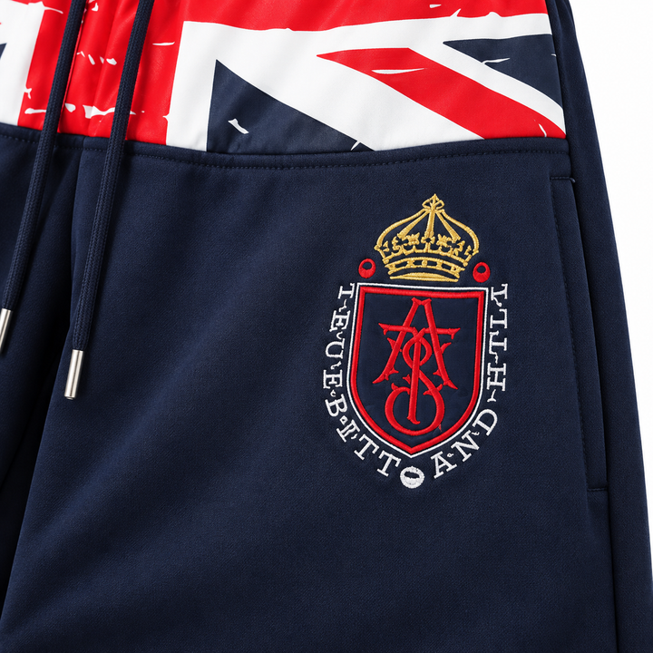 Close-up of crest embroidery and navy fabric on wide leg sweatpants