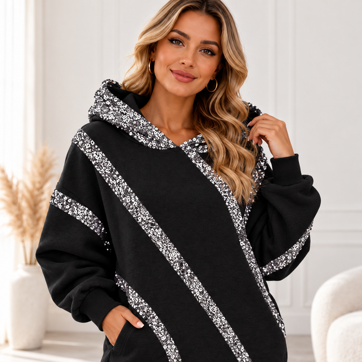 Close-up of black hoodie with silver embellishment around hood and across sleeves