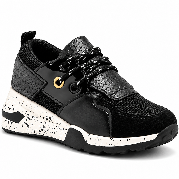 Black sneaker close-up showing eyelets and textured upper