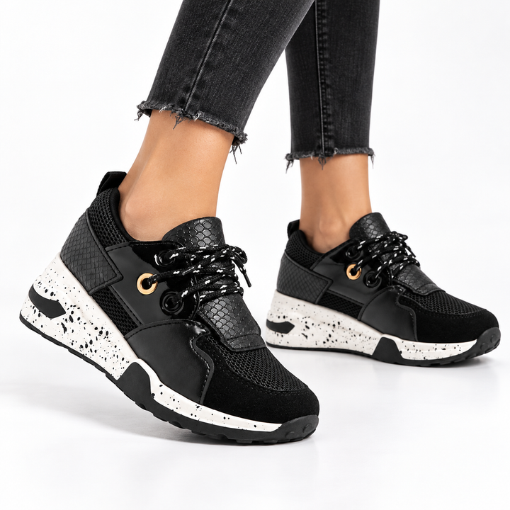 Black lace-up sneakers with distressed dark jeans