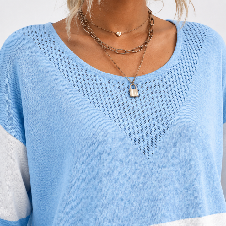 Close-up of the sky blue color block ribbed sweater showing the round neckline and textured V-shaped knit chest detail.