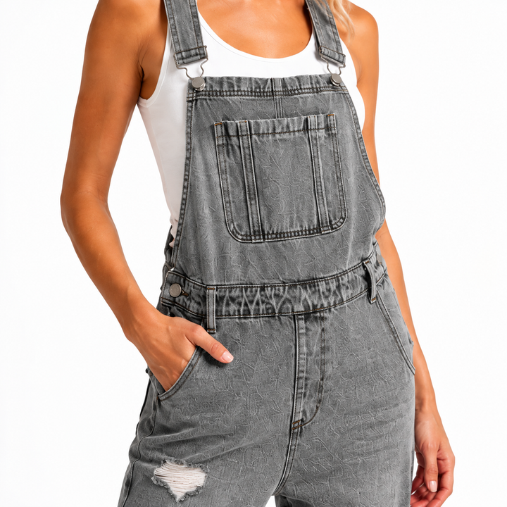Gray 9145 cropped denim overalls close-up showing adjustable straps, metal parts, bib pocket, stitching and distressed denim.