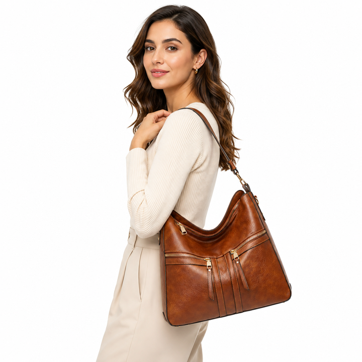 Brown double zipper tote carried by a woman on white, showing full front design, shoulder strap, zip pockets and proportions.