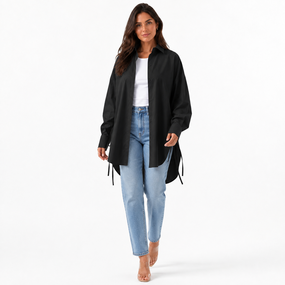 Black oversized drop shoulder shirt styled open with a white top and jeans in a clean professional studio photo.