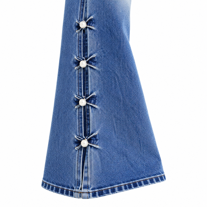 Close-up of blue flare jeans lower leg with decorative side tie details
