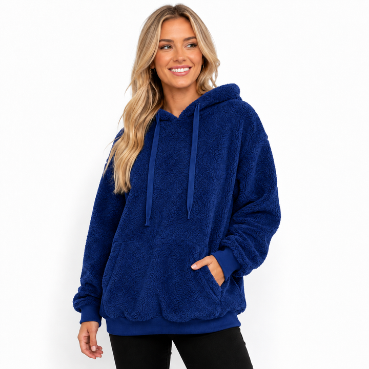 Blue hooded fleece pullover studio view showing textured surface, drawstrings, kangaroo pocket, ribbed cuffs and loose shape.