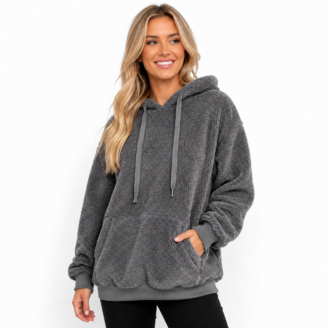 Charcoal gray hooded fleece pullover on a model showing textured surface, long drawstrings, kangaroo pocket and ribbed cuffs.