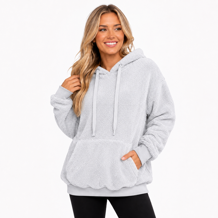Light gray hooded pullover hero view showing fleece texture, hood, drawstrings, front pocket and relaxed fit on studio model.