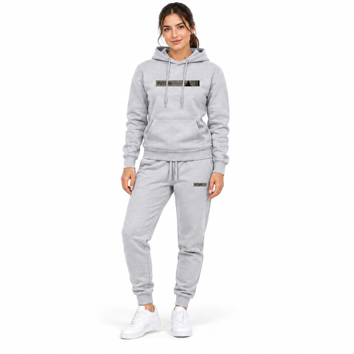 Woman wearing the light gray hoodie and matching light gray pants set on a white background