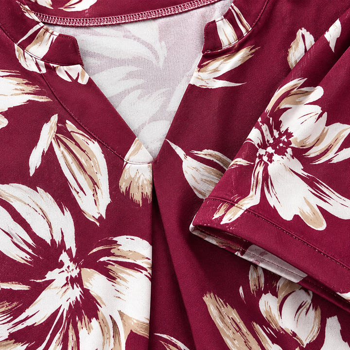 Macro view of the burgundy floral blouse showing the printed surface, seam finish and garment detail against a clean studio background.