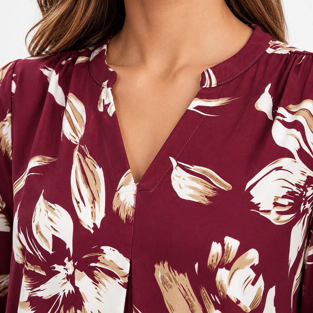 Close-up of the burgundy floral blouse V-neckline showing printed floral details, neckline construction and stitching in studio view.