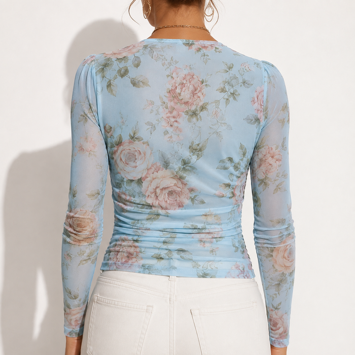 Blue floral long sleeve top shown from the back with fitted shaping, printed sleeves and a clean studio product presentation.