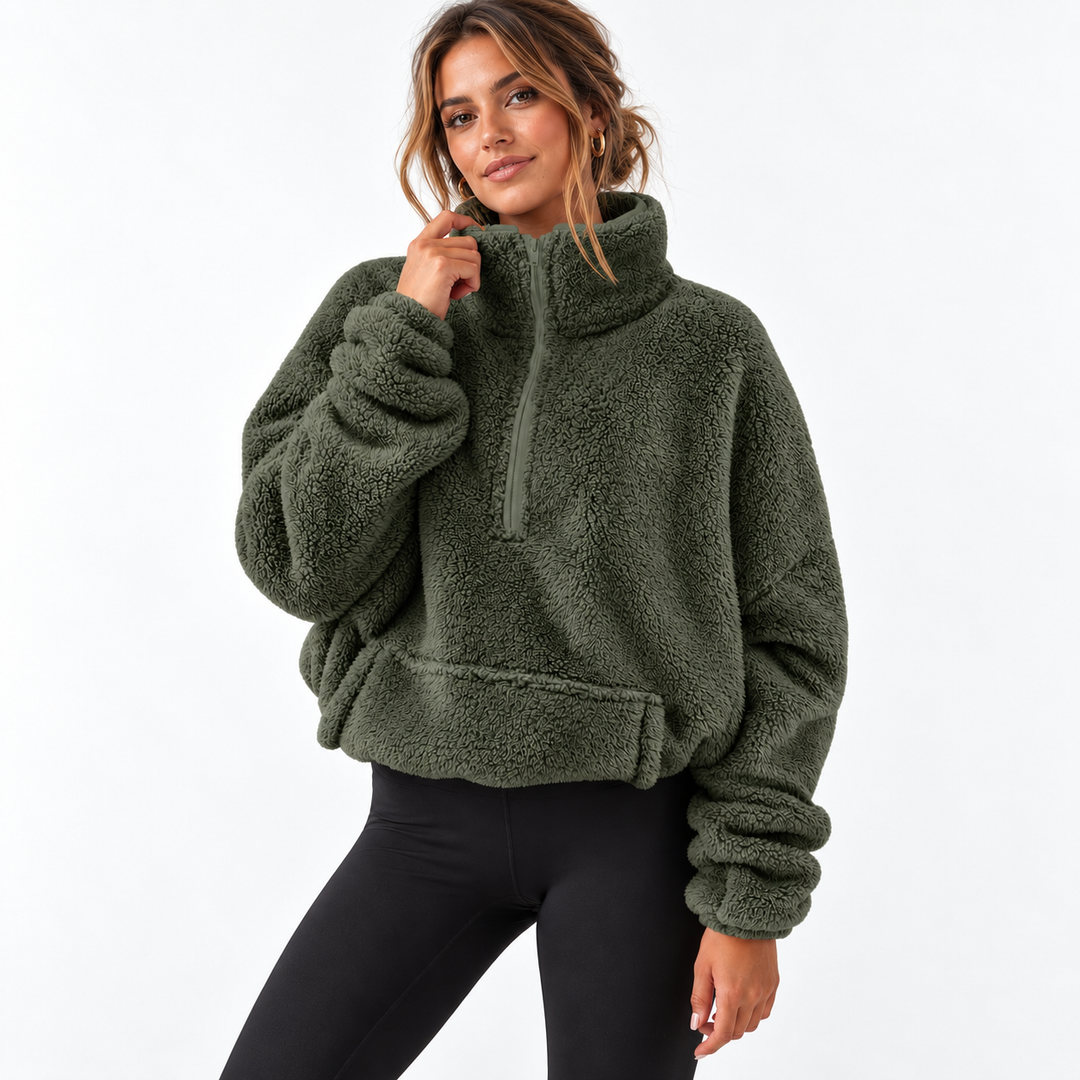Army green half zip fleece sweater on a model in a clean studio setting, showing the stand collar, long sleeves and front pocket.